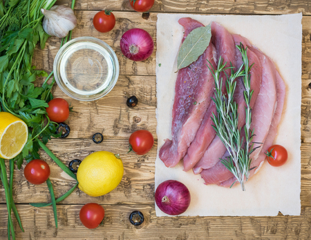 Sliced raw meat of pork with spices and vegetables on a rustic table. Home cooking with natural products.の写真素材