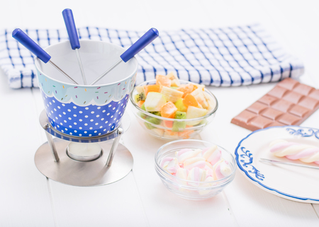Fondue chocolate, marshmallows, apple, tangerine, kiwi and banana. Homemade holiday dish. Children's party.の写真素材