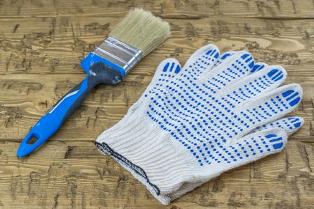 Brush with gloves on a wooden table. Tools for wood tinting.の写真素材
