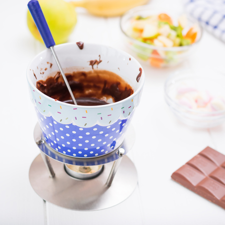 Ingredients for chocolate fondue on a white wooden table. Homemade holiday dish. Children's party.の写真素材
