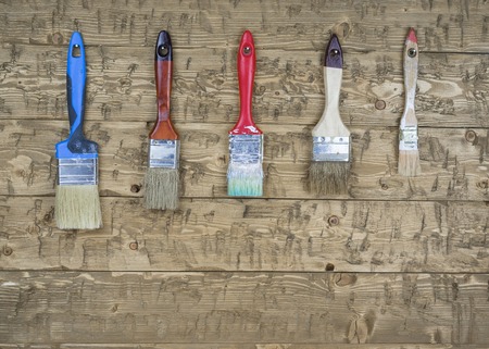 A set of used brushes hanging on the wall. Tools for painting various surfaces.の写真素材