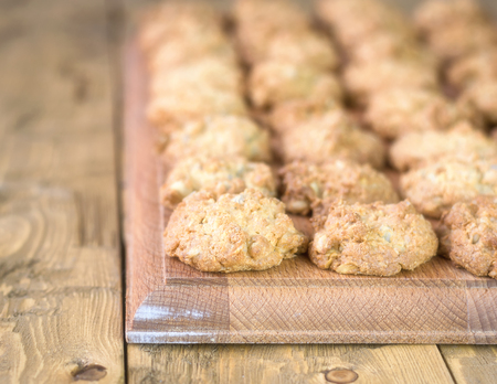 Freshly baked cookies from oatmeal with sunflower seeds. Homemade cakes on wooden rustic table.の写真素材