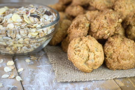 Homemade cookies on a piece of burlap and a bowl of muesli on a wooden table. Homemade cakes on wooden rustic table.の写真素材