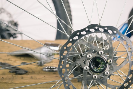Rear wheel mountain bike and tools on a wooden table. The concept of Bicycle repair.