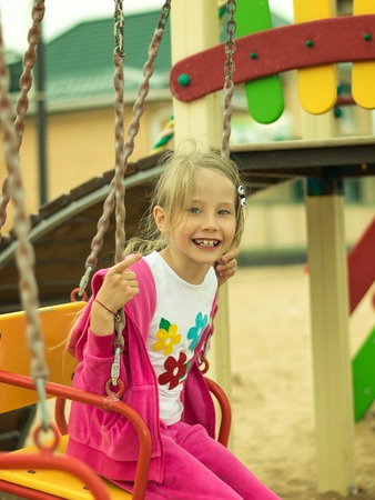 Girl fun riding on the swings in the gaming system.の写真素材