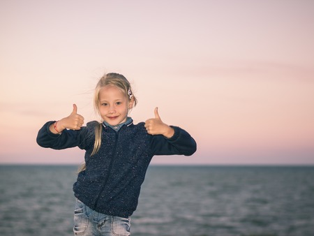 The girl in the sea shows two hands that all is well.