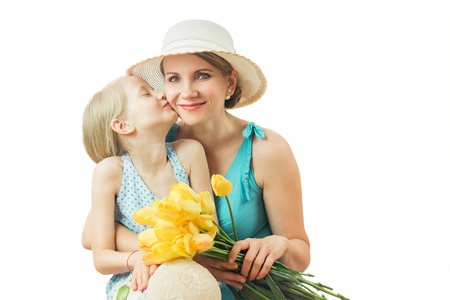 Mother kissing daughter isolated on white background.の写真素材