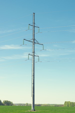 Support high-voltage power line on blue sky background. Equipment for transmitting electric current of high voltage.の写真素材