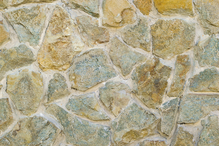 A fragment of an artificially made wall of stone and binder solution. Background of stone wall.の写真素材