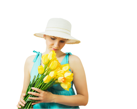 Woman in summer hat with a bouquet of tulips isolated on white background. Portrait of beautiful woman with flowers on white background.の写真素材