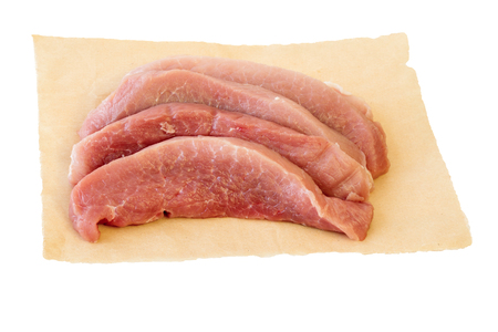 Pieces of fresh pork on paper isolated on white background. Fresh pork meat for cooking delicious roast.の写真素材