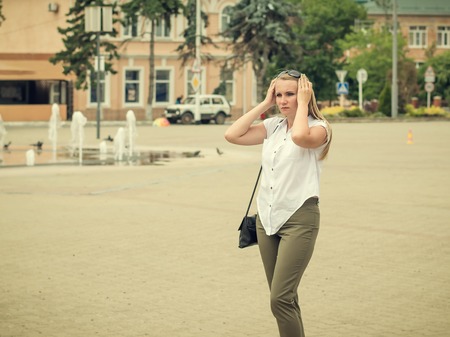 The woman straightens her hair on the background of the old city.の写真素材