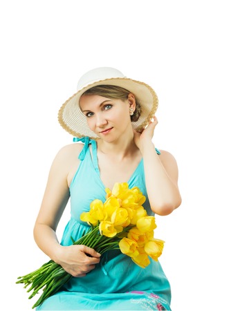 Woman in summer hat with a bouquet of tulips isolated on white background. Portrait of beautiful woman with flowers on white background.の写真素材