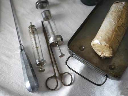 Set of vintage medical instruments on a white cloth. The concept of the past medicine.の写真素材