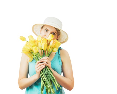 Woman in summer hat with a bouquet of tulips isolated on white background. Portrait of beautiful woman with flowers on white background.の写真素材