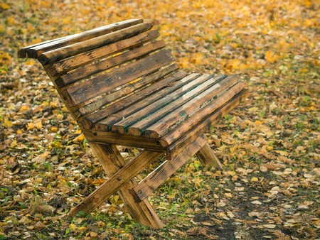 Beautiful wooden bench in autumn city Park. Place in the city Park.の写真素材