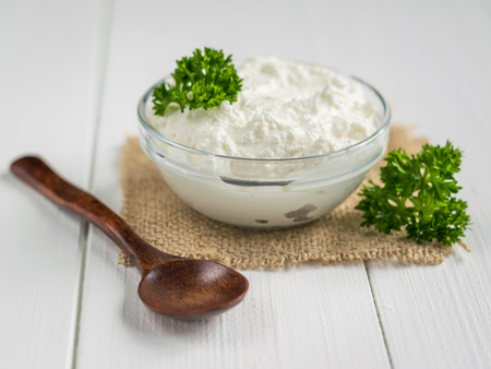 A fresh slice of bread smeared with cottage cheese cream with parsley on the table. The concept of a healthy diet. Curd creamの写真素材
