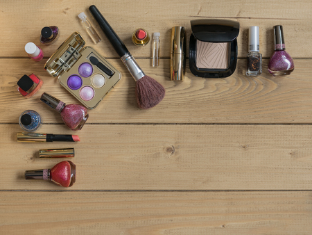 Eyeshadow, brush, lipstick on a vintage wooden table. Set of beautiful women's cosmetics on the table.の写真素材