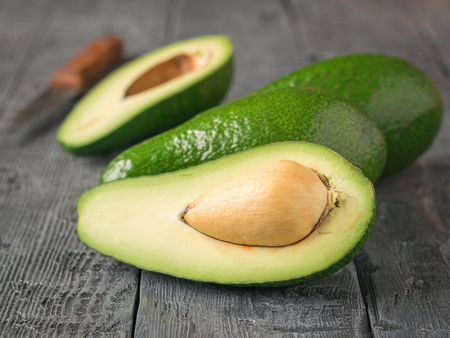 Ripe avocados on wooden rustic table. The concept of a vegetarian diet. A healthy lifestyleの写真素材