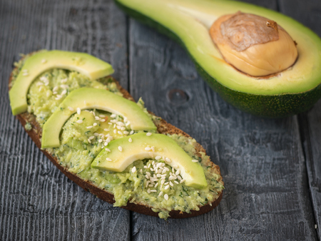 Cream puree avocado with parsley, dill and garlic in a bowl on a vintage table. The dish is...