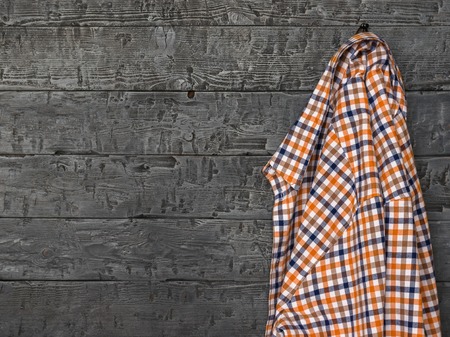 Mens shirt colorful plaid hanging on a wooden wall. Clothes for everyday use.の写真素材