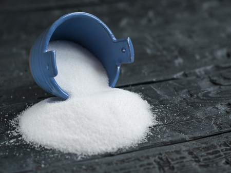 Sea salt fine grind the shaker blue on a rustic table. Natural sea salt is bright white.の写真素材