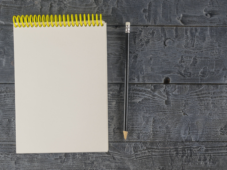 Note book and black pencil on a dark wooden table. The view from the top. Place for your text. View from above,の写真素材