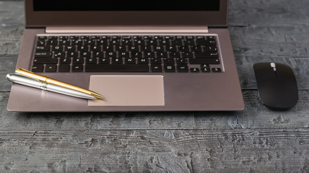 The gray notebook and two ballpoint pens on vintage wooden table. Workplace designer. Work outside of the office.の写真素材