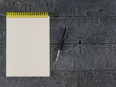 Note book and black pencil on a dark wooden table. The view from the top. Place for your text. View from above,の写真素材