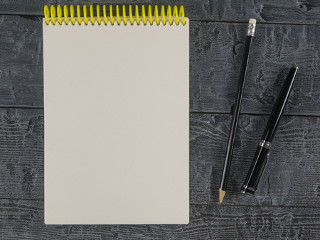 Note book and black pencil on a dark wooden table. The view from the top. Place for your text. View from above,の写真素材