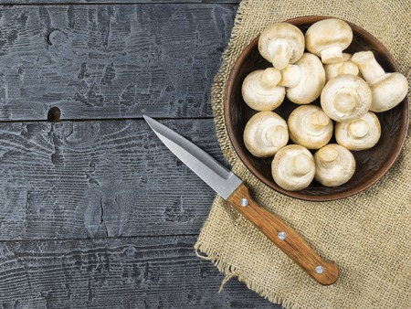 Fresh mushrooms with leaves parsley on a rustic wooden table. Vegetarian food is on the table. The view from the top.の写真素材