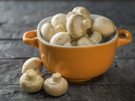 Fresh mushrooms in a yellow bowl on a rustic wooden table. Vegetarian food is on the table. Healthy eating.の写真素材