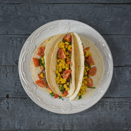 Freshly prepared Mexican tacos on a plate on a rustic table. The view from the top.の写真素材