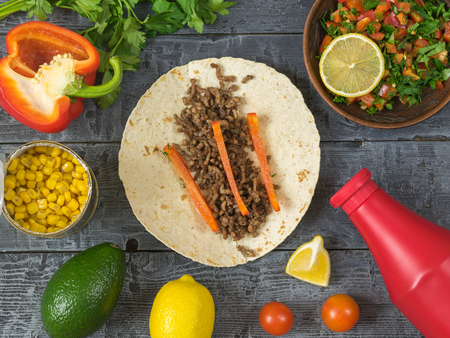 Cake made of corn flour, avocado, pepper, lemon, lime, parsley, corn. Ingredients for making Mexican tacos. The view from the top.の写真素材