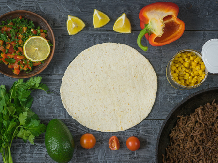 Cake made of corn flour, avocado, pepper, lemon, lime, parsley, corn. Ingredients for making Mexican tacos. The view from the top.の写真素材