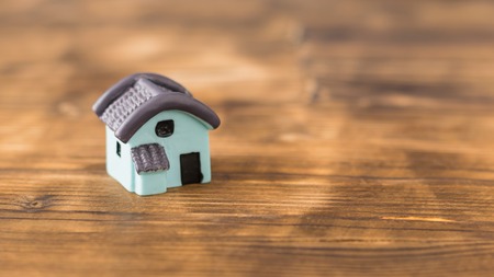 A model of a small blue wooden house on an orange background.の写真素材