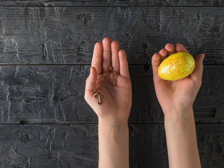 Gold decoration and Easter egg in the hands of a child.