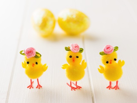 Three toy Chicks and Easter eggs on a white wooden table. The decoration of the Easter table. Great Christian holiday.の写真素材