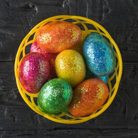 Basket with colorful eggs on a black rustic table. Decorations for the Easter table. The view from the top.の写真素材