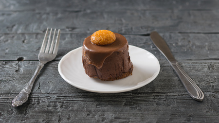 Cake on a white plate with fork and spoon on a dark wooden table. Delicious dessert on the rustic table.の写真素材