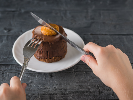 The child eats fresh dessert with a knife and fork. Delicious dessert on the rustic table.の写真素材