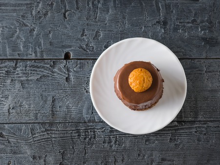 Cake on a white plate on a dark wooden table. Delicious dessert on the rustic table. The view from...