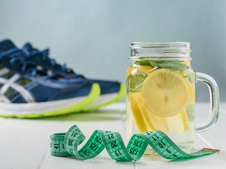 A freshly prepared drink made of lemon and mint on the background of sneakers wooden floor. Blue wall.の写真素材