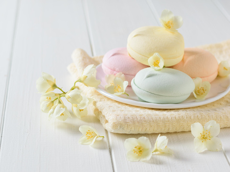 Colorful macaroons with Jasmine flowers on a white wooden table. The composition of the dessert on the village table.の写真素材