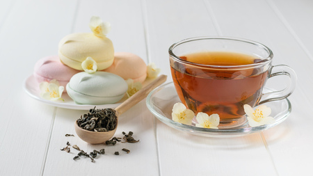 Freshly prepared tea and three colored marshmallows on a white wooden table. The composition of the morning Breakfast. Spring tea composition on a white table.の写真素材