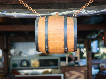 A barrel of wine, hung on a chain at the entrance to the bar. The concept of storage of old alcohol.