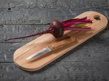 Fresh red beets with a knife on the chopping Board. Health food. Vegetarian food.の写真素材