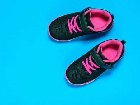 Black with red children's sneakers on a pastel background. Colorful sports shoes.の写真素材