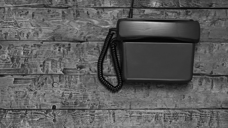 Retro phone without the possibility of dialing on a black wooden table. The view from the top. Flat lay.の写真素材