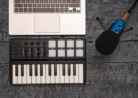 Electronic music mixer and wire microphone on a black wooden table. Equipment for the music Studio....